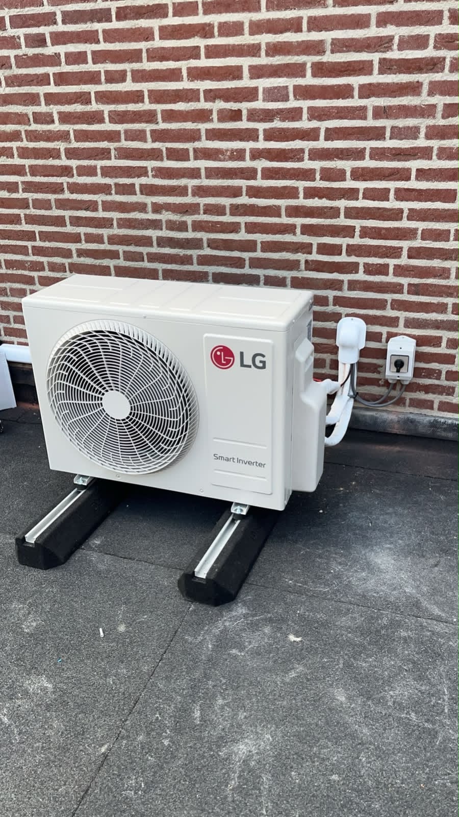 Ge&iuml;nstalleerde LG buitenunit van een airco bij een woning